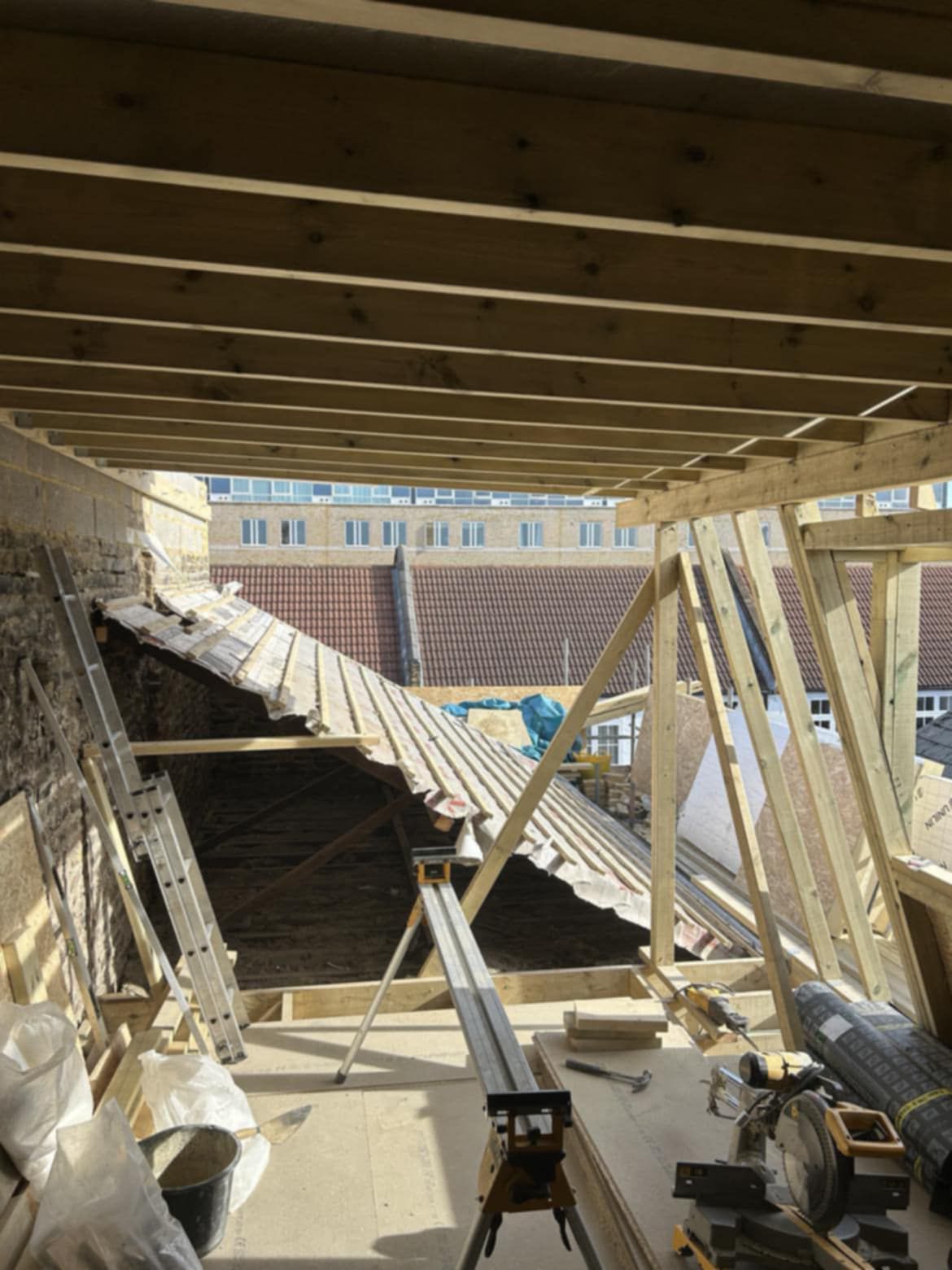 inside of an attic in Birmingham with wood and other tools laying around during a roof installation